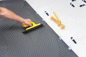 Снимка - нанасяне на лепило върху основата на пода