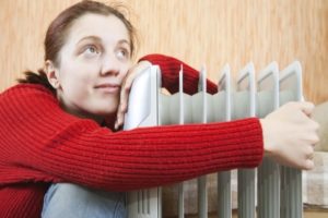 Снимка: Момиче прегръща радиатор