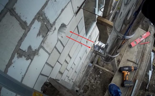 Снимка на страничен изход на тръбен тройник срещу проходен отвор в стената