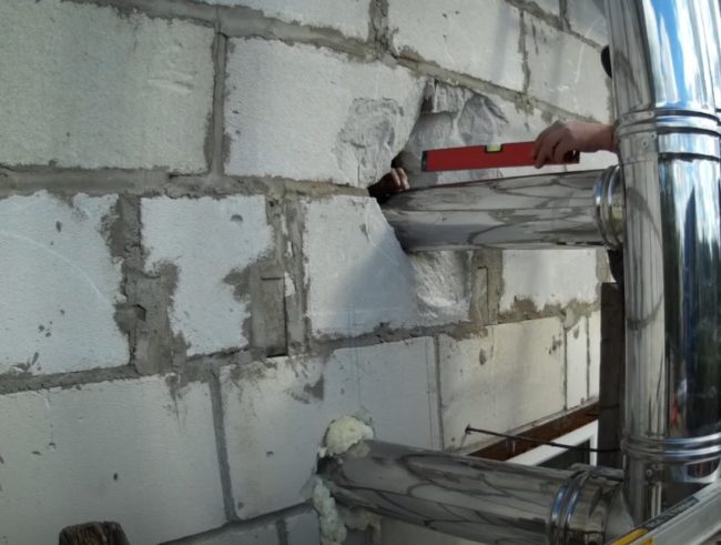 Снимка: Монтаж на странични канали от тръби в къщата през проходни отвори