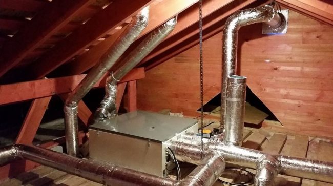 Снимка на рекуператор за вентилационна система с канали и изпускателна система на тавана