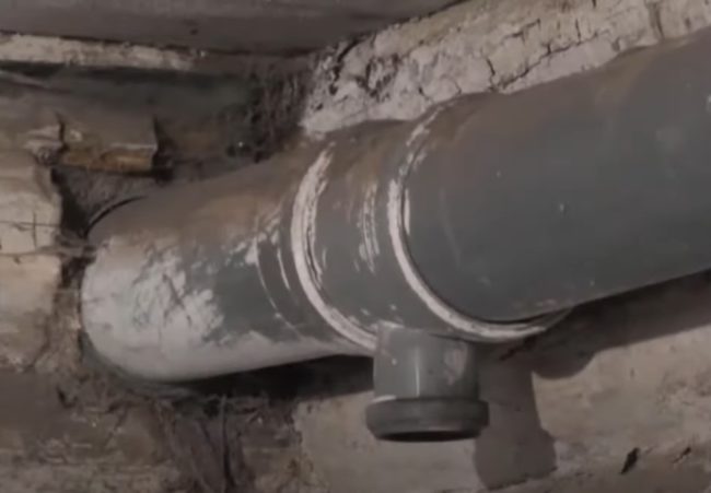 Снимка на тройник на изпускателен канал, монтиран на тавана, със свободен отвор без тръба, слизаща към пода