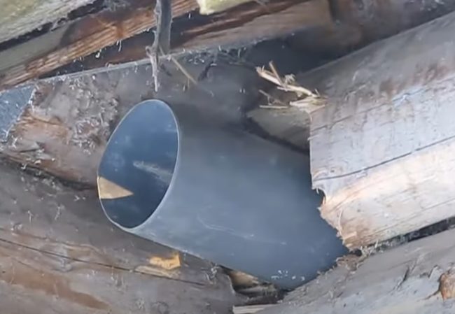 Снимка на изпускателната тръба, водеща навън през отвор в стената