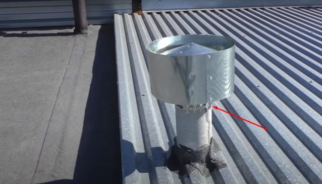 Снимка на дефлектор, закрепен със скоба към изпускателната тръба на покрива.