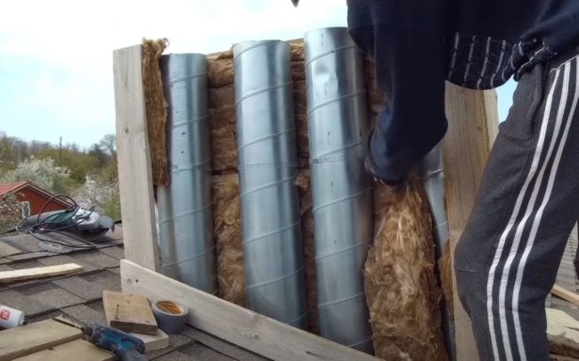 Снимка: Изолиране на вентилационни тръби вътре в кутия с минерална вата