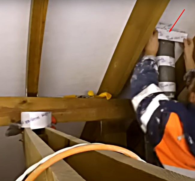 Снимка: Закрепване на краищата на отрязаната пароизолация на покрива към вентилационния щранг с тиксо