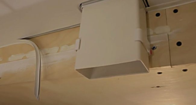 Снимка: Изход изпод опънатата тъкан на правоъгълна кутия за свързване на абсорбатор с гофрирана тръба чрез адаптер