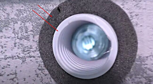 Снимка на изолация на тръба и втулка на клапан, поставена в отвор в стената